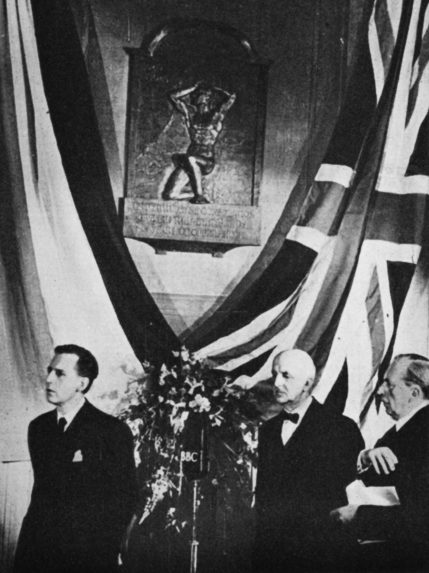 Three men in front of Union and Netherlands flag
